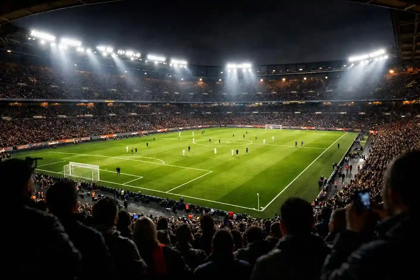 Blick von der Tribüne auf ein beleuchtetes Fussballfeld während eines Abendspiels